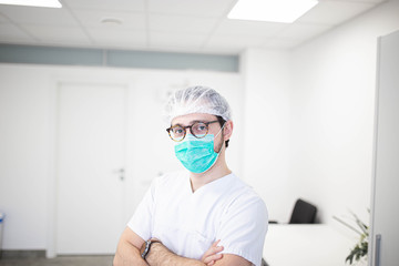 Fototapeta na wymiar male surgeon with glasses and a surgical hat in a white coat m mask on a white background.