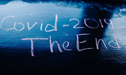 concept of the end of the coronavirus pandemic, the inscription on the chalk blackboard COVID -2019  end.