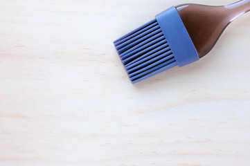 rubber or silicone brush with a plastic handle for pastry on the table in the kitchen. The...