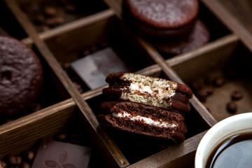 Sweet snack with coffee. White Cup of coffee,chocolate and half-eaten Choco pie.