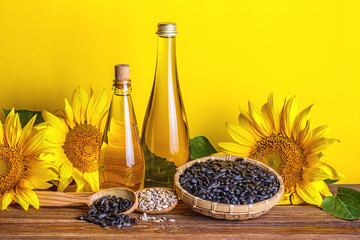 Rural still-life - sunflower oil in bottles with flowers of sunflower (Helianthus annuus), closeup