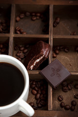 Sweet snack with coffee. White Cup of coffee,coffee beans,chocolate and half-eaten Choco pie.