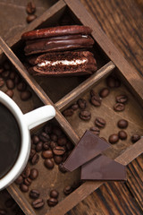 Sweet snack with coffee. White Cup of coffee,coffee beans,chocolate and half-eaten Choco pie.