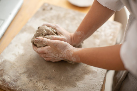A woman prepares clay for the production of ceramic utensils. Craft production. A close-up.