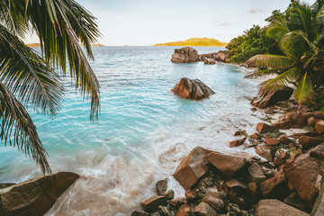 Sunset at tropical beach Anse Patates with granite boulders on La Digue Island, Seychelles