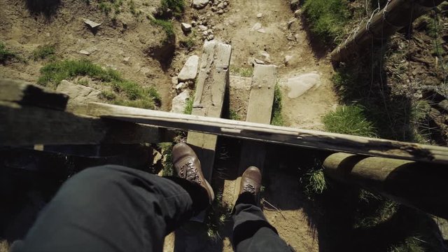 Walking over a wooden stile fence in the countryside, slow motion.