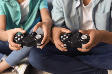 African-American teenagers playing video game at home, closeup