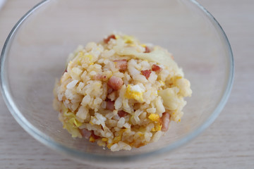 Homemade golden fried-rice with egg, chopped sausage, and sliced cabbages.