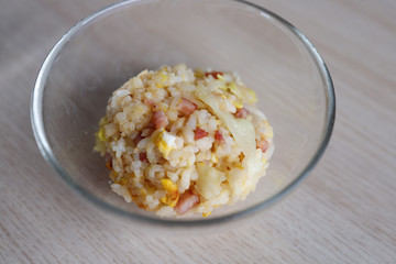 Homemade golden fried-rice with egg, chopped sausage, and sliced cabbages.
