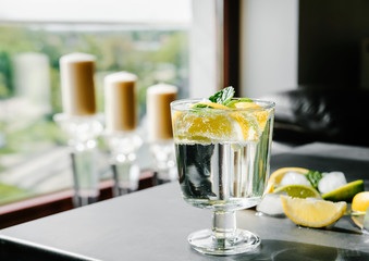 Refreshing iced infused water with lime, lemon and mint on dark background. Summer drink, cocktail concept.