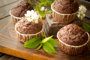 Chocolate maffins with cherry flowers on rustic table