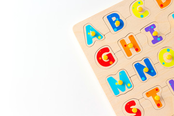 Concept of early learning children reading. Wooden kid game board with letters of the alphabet. Copy space for text.