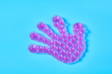 One rubber toy child palm with many suction cups on blue background. Symbol of friendship. Concept of peace at world