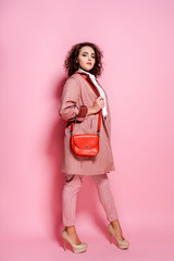 Young elegant woman in trendy pink coat. isolated studio shot.