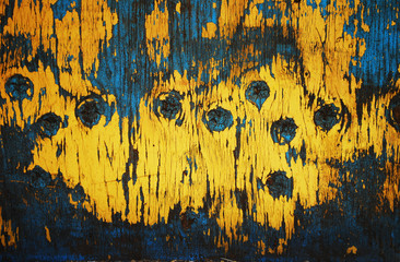 Texture of wood with shabby paint in blue and yellow colors