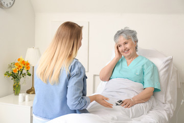 Obraz premium Young woman visiting her grandmother in hospital