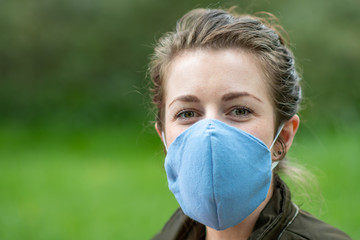 A young woman wears a home made face mask shield to prevent spread of covid coronavirus pandemic