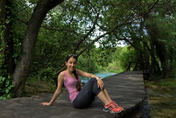 a young girl posing with sportswear on a rustic road surrounded by nature