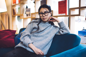 Obraz premium Peaceful Asian woman relaxing in cozy living room