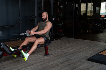 Obraz na płótnie Canvas Bodybuilder Exercising Back On Machine