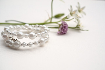 White bracelet on the table with flowers