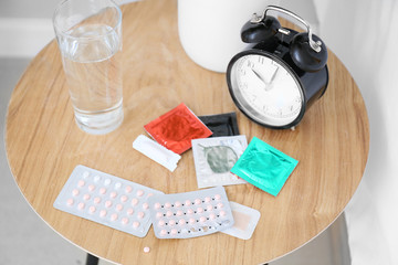 Different means of contraception and clock on table