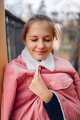 Young girl teenager with shut eyes. Teen standing in park smiling and thinking