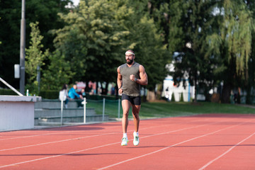 Fototapeta na wymiar Young Male Athlete Running on Track