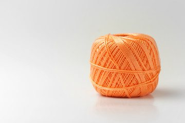 Skein of thread of orange color. Knitting threads on a white background. hobby.