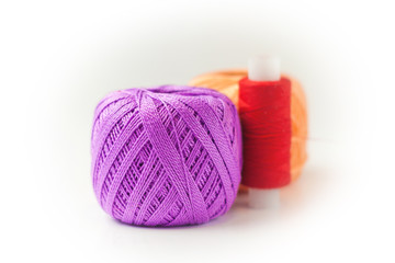 Two skeins of thread in purple and orange. Knitting threads on a white background. hobby.