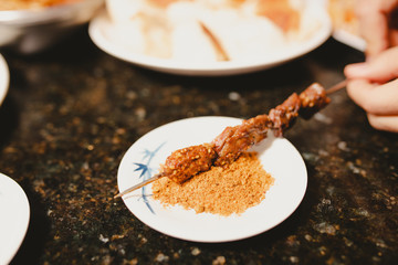 Dipping chinese kebab into seasoning