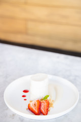 Cheesecake with piece of strawberry and wooden background