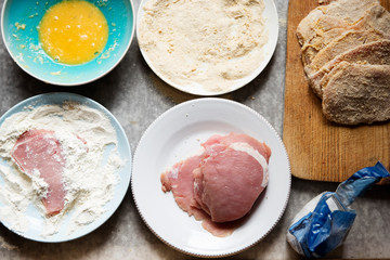 Preparing breaded pork chops, polish kotlety. Flour, whisked egg, bread crumbs. 