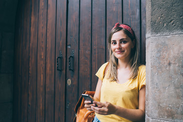 Obraz premium Content female traveler browsing cellphone in city