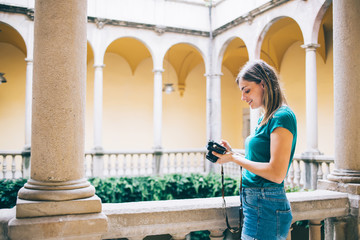 Cheerful traveling woman using photo camera