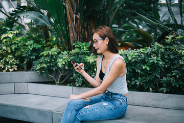 Woman browsing smartphone sitting on bench