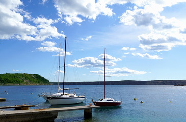Picturesque seascape with three small yachts moored at the pier