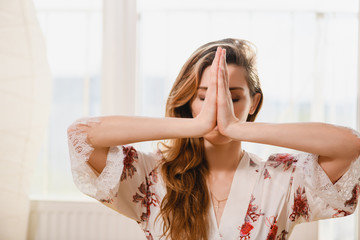 Woman holding hands in namaste or prayer