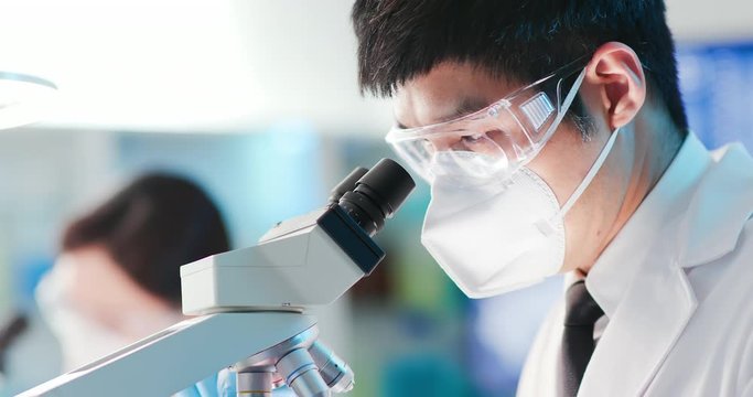 man scientist use microscope