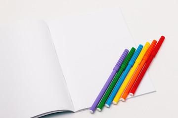 LGBT flag for paint markers resting on blank page of a notebook