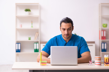 Young male dentist working in the clinic