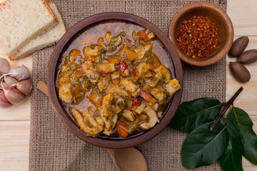 spanish tripe dish on wooden table with rustic tablecloth