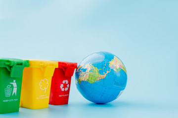 Yellow, green and red recycle bins with recycle symbol on blue background. Keep city tidy, Leaves...
