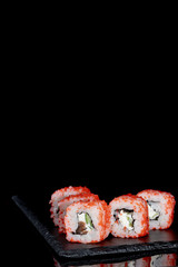 Philadelphia roll with salmon, cheese and cucumber on a black background with reflection. Sushi Philadelphia