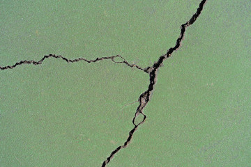 background of a crack in green painted blacktop of a tennis court