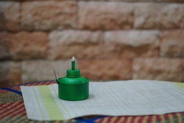 Traditional lamp and ketupat on Asian textured background