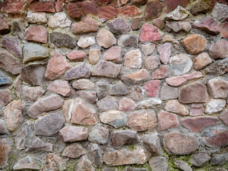 Texture of an old stone wall with cement. Uneven texture of natural stone with cracks for design or background