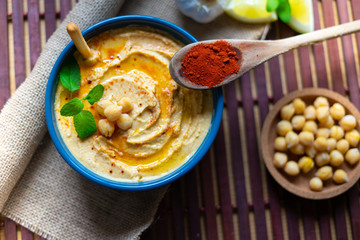 Hummus. Healthy homemade chickpea hummus with olive oil, lemon and paprika. Wooden background