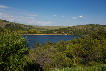 summer landscape, the river meanders and goes into perspective one bank of the river is steep and...