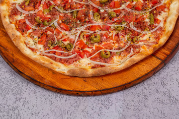 pepperoni pizza with tomatoes, olives and onion on gray background.top view